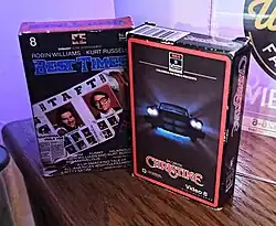 Two Video8 home releases on a wooden shelf