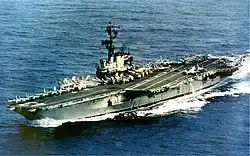 Medium-size aircraft carrier with numerous aircraft on its flight deck.