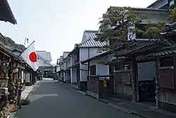 Street lined with wooden houses with white walls.