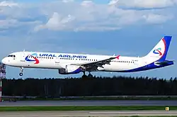 An Ural Airlines Airbus A321 landing, photographed just above a runway in clear weather conditions