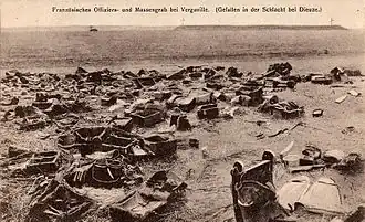 des effets militaires abandonnés jonchent le sol, on distingue un képi et des caisses dans un grand désordre