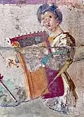 1st century CE, Herculaneum. Woman playing kithara; 2 straps are visible that holds the instrument up while she uses both hands to play (one blue, one yellow).