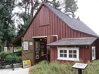 A red barn with white trim and a shingle roof