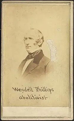 Photograph of Wendell Phillips with the caption "Wendell Phillips, abolitionist"; there is an abrasion on the right side of the image, above the subject's shoulder