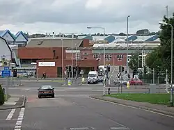 Red brick factory buildings seen across roads and traffic light controlled junction.