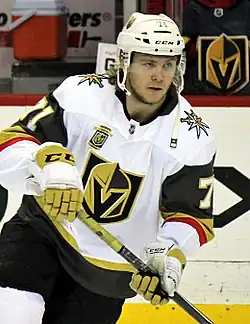 Hockey player skating in white Vegas Golden Knights jersey