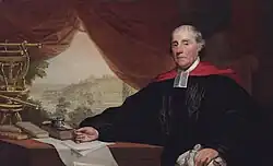 White male with gray hair in academic robes with preaching tabs