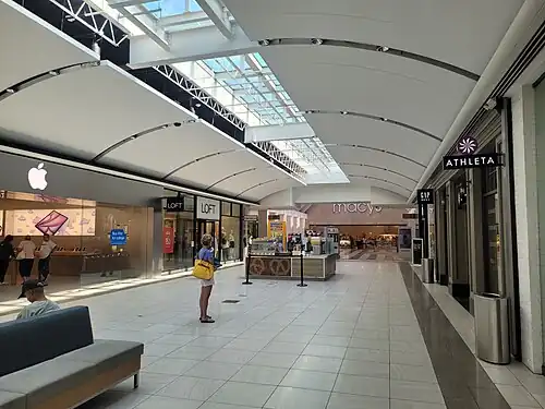 Interior hallway, 2025, showing an Apple Store, a Macy's, and others.