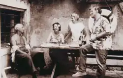Sepia photograph of three people around an outdoor table, laughing