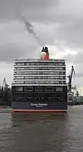 Moving forward very slowly (against the tide), the ship approaches the dry dock.