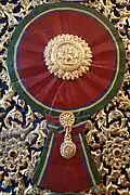 A woodcarving of "Maha Varabhorn", the Knight Grand Cross (First Class) of the Order of the White Elephant, version that was used from 1869 to 1909, at the gates of Phra Vihara of Wat Ratchabophit Sathit Maha Simaram, Bangkok.