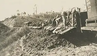 Workers emptying excavated soil from carriages next to the railway line, Kokotungo, 1928