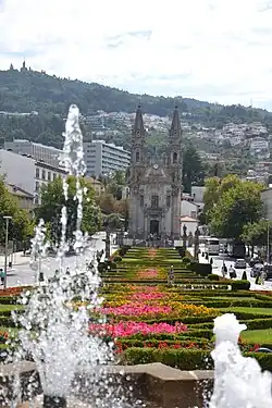 Photograph depicting the gardens and fountain in front of the Santos Passos Church.