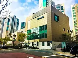 Image of a large square manilla and brown building on a sunny day.