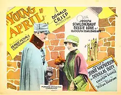 Vintage lobby card with a man in a light blue military coat offering flowers to a smiling woman in a green hat and pink coat, set against a stylized stone wall background