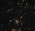 In SDSS J0952+3434, the lower arc-shaped galaxy has the characteristic shape of a galaxy that has been gravitationally lensed.[51]