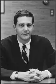 A portrait of Jeb Magruder at a table