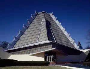 Exterior of Beth Shalom Synagogue, a concrete, steel, and glass building with a pyramidal roof