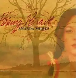 blending of headshot photo of half of Amanda Shires face with yellow toned photo of bare tree and clouds with album title and name