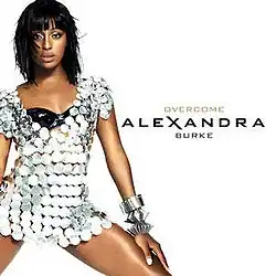 Image showing a young woman wearing a short silver sparkly dress with a black bra underneath, on white background. The words "Alexandra Burke" and "Overcome" are written to the right of the woman.