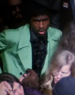 Hunter, amidst other concertgoers, wearing a green suit and a black shirt
