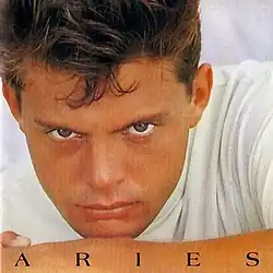 A man wearing a white shirt is front of the camera and laying down.