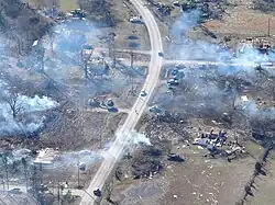 An aerial shot of a cloudy street with debris strewn across the ground.