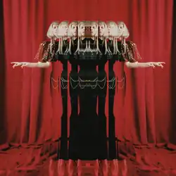 An edited photograph of Aurora that shows several reflections of her with a dark green dress, while standing on tiptoes. Behind her is a backdrop of red curtains that also cover the lower corner of the image.