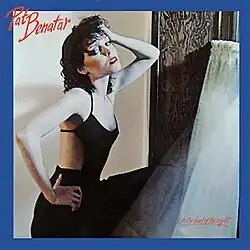 photo of Pat Benatar in an interior space in black spaghetti straps looking aside with hand in hair