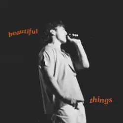 a monotone photo of Benson Boone performing with the song's title printed beside him in groovy lowercase orange lettering; 'beautiful' printed on his left, 'things' on his right.