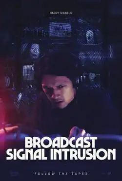 A man listening to a broadcast signal. Behind him are several screens showcasing the distorted face of a woman.