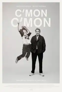 In black and white, a young boy jumps from the ground. A serious looking older man glances at him, with a slightly annoyed expression.