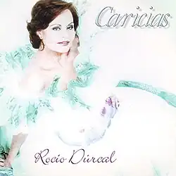 Rocío Dúrcal looking up in a large white dress with teal and magenta accents.
