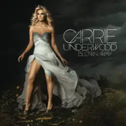 Underwood standing in a windswept field wearing a grey gown against a dark and stormy sky