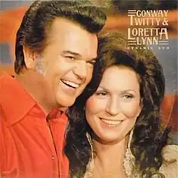 photo of Conway Twitty and Loretta Lynn smiling looking off-camera