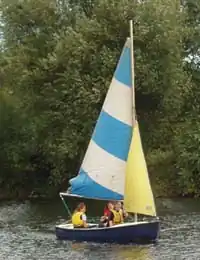 A coypu underway with three children on board, a blue hull and colourful sails