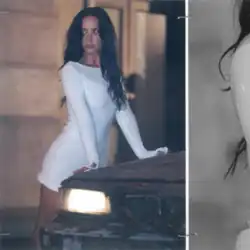 Lovato leaning on a car hood and glancing sideways