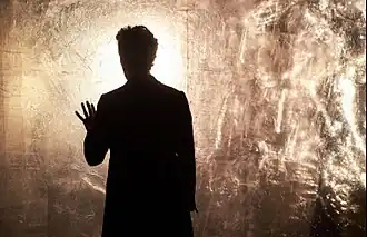 A man is inspecting a crystalline wall.
