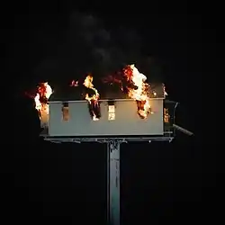 A burning house shown over a black background