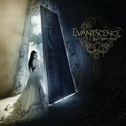 A woman in a dress standing in the entryway of a building, with light shining upon her. In the top right corner of the image, the words "Evanescence" and "The Open Door" are placed.