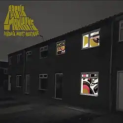 A black-and-white image of a housing estate with windows revealing coloured patterned walls. The artist name and album title are written in dark yellow in the top left.