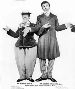Short, plump white man wearing hat, standing next to tall thin one holding his hat; both strike open-handed comic poses, perhaps shrugging.