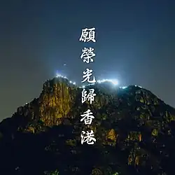 An image of Lion Rock at night with lights glowing from a distance. The song's title is read in Chinese characters vertically.