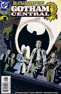 Five police officers on a rooftoop, standing in front of the 'Bat signal' searchlight.