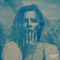 Halsey holding her right hand over her mouth