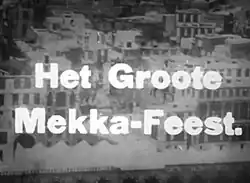 The text Het Groote Mekka-Feest superimposed over a black-and-white photograph of a city, featuring multiple buildings with flat roofs.