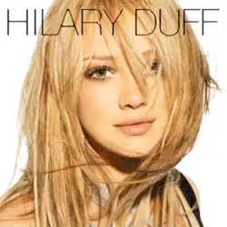 Duff facing a camera while standing in front of a white square