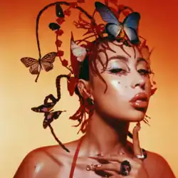 A portrait of Uchis wearing a decorative headpiece with butterflies resting around her head.