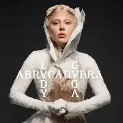 Gaga wearing a white outfit and standing behind the song's title