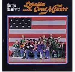 photo of Coal Miners band with Loretta Lynn and US flag background